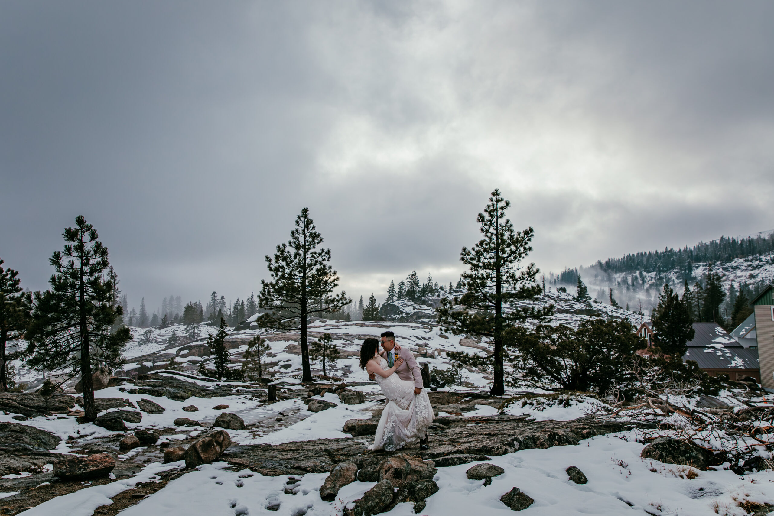 Groom dipping the bride on snowy granite terrain during their October Donner Summit elopement portraits.