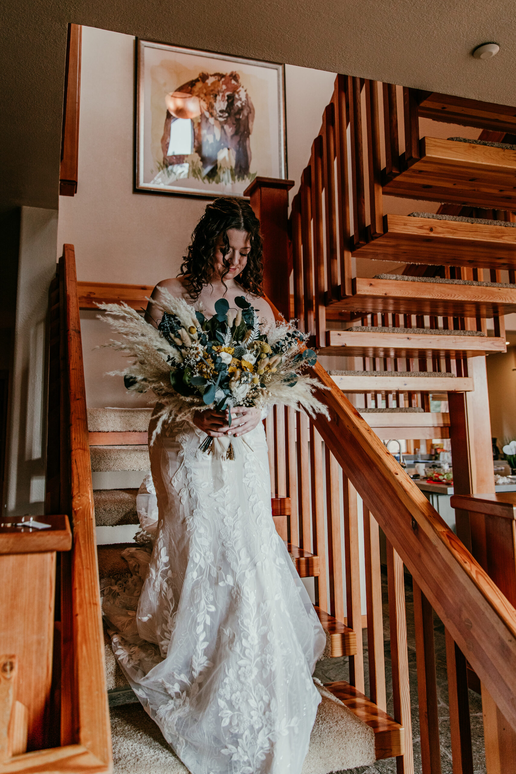 Bride walking down wooden stairs inside a cozy Lake Tahoe Airbnb on her elopement day.