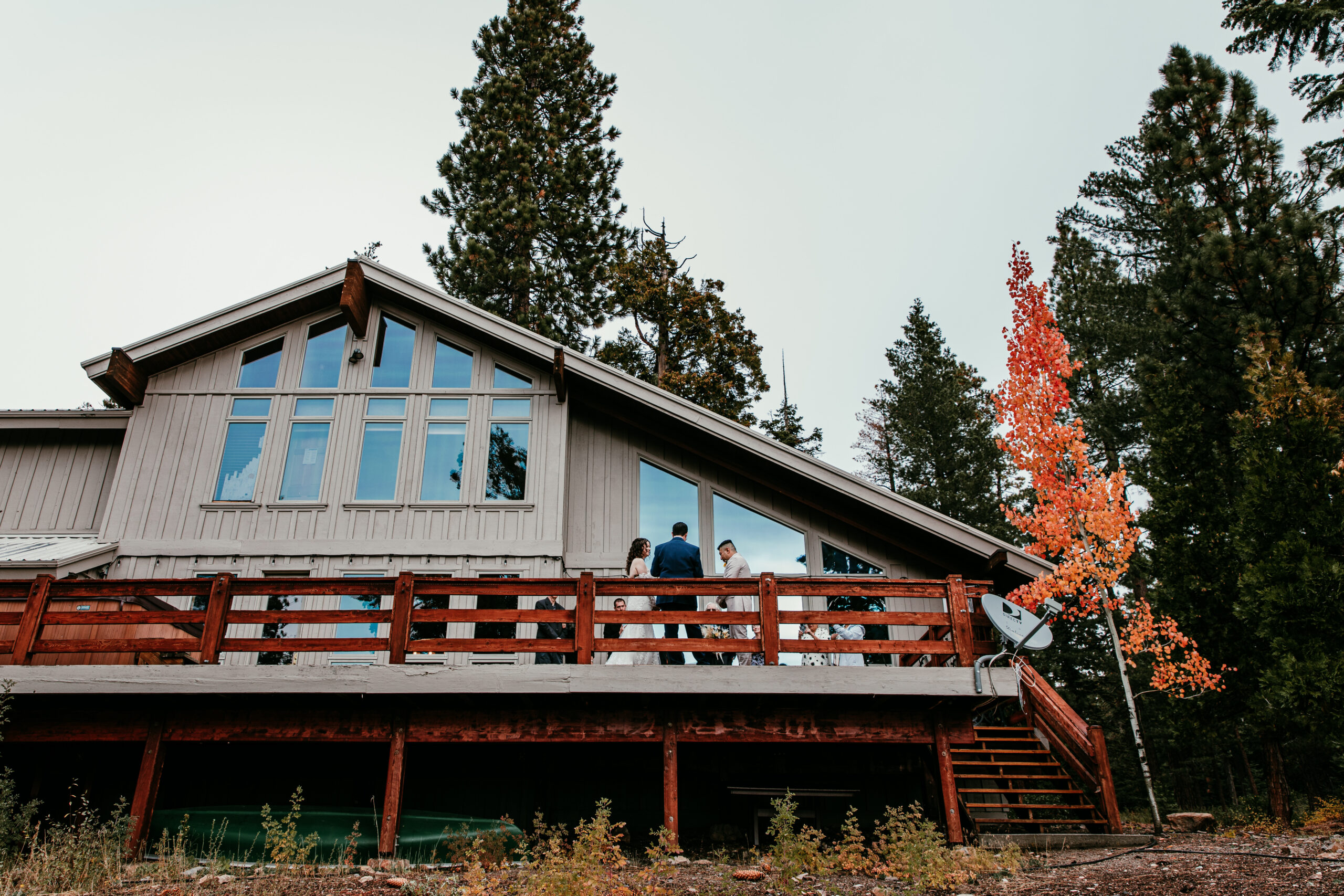 Lake Tahoe Airbnb with a vibrant red and orange fall tree beside the ceremony deck in October.
