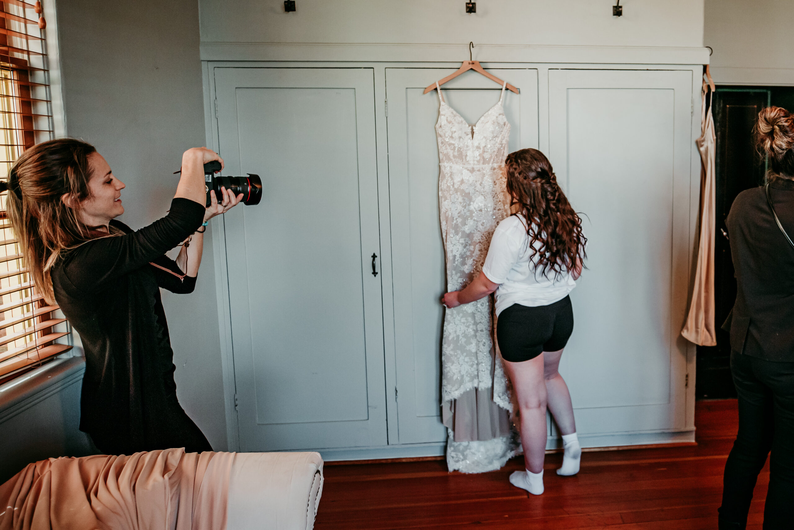Elopement photographer capturing a bride choosing her wedding dress during the getting ready portion of an intimate elopement day.