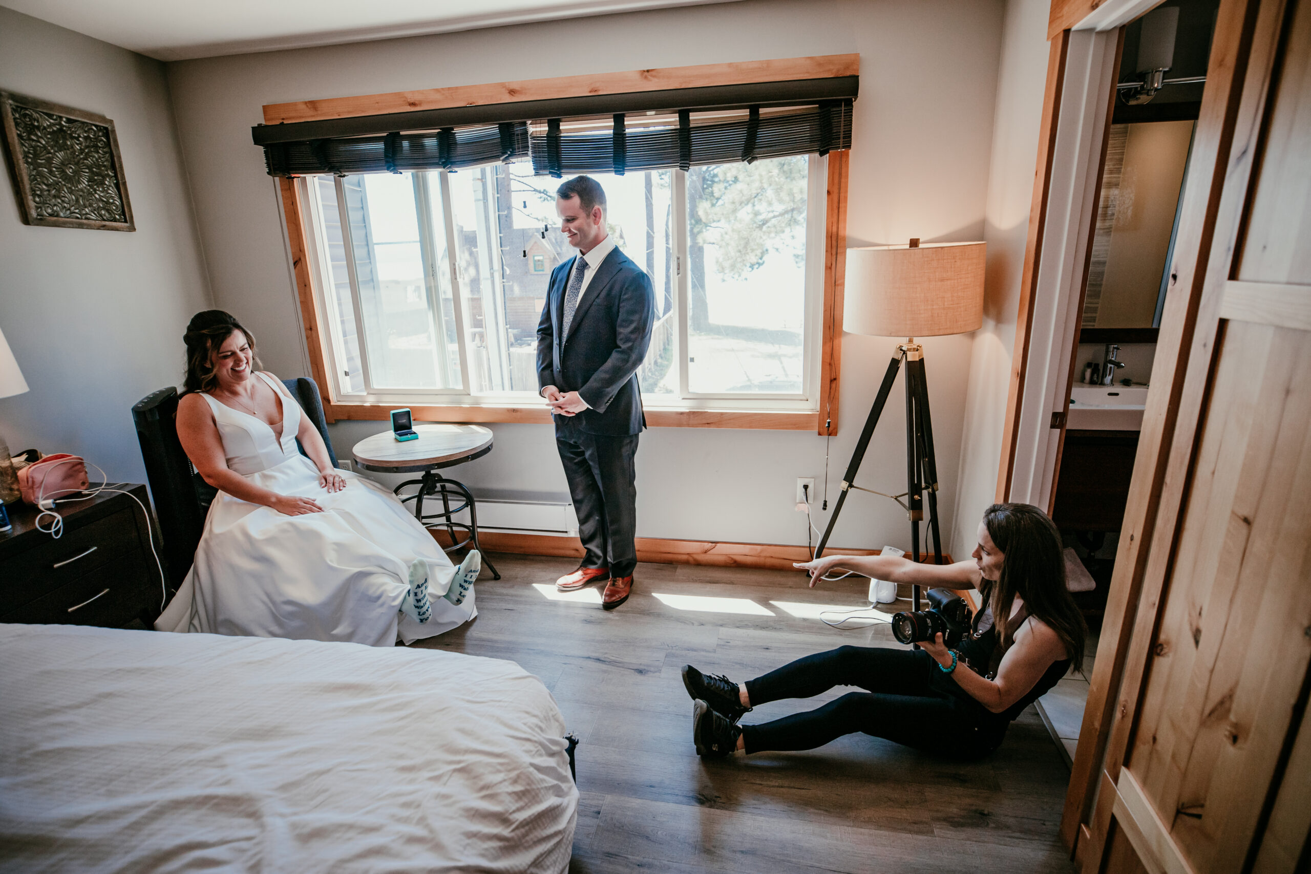 Elopement photographer capturing candid laughter as a bride and groom get ready together before their intimate wedding ceremony.