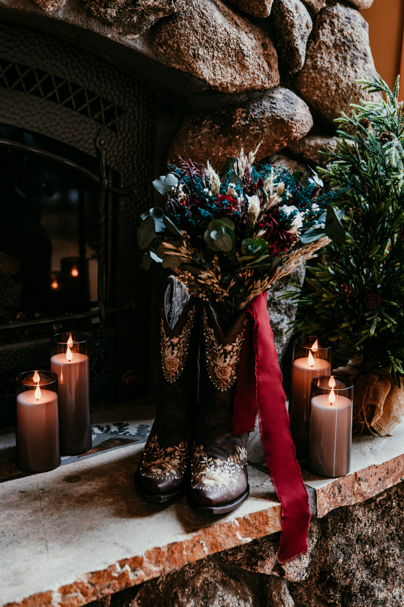 Rustic wedding boots and bouquet by a fireplace highlighting cozy elopement ideas in California