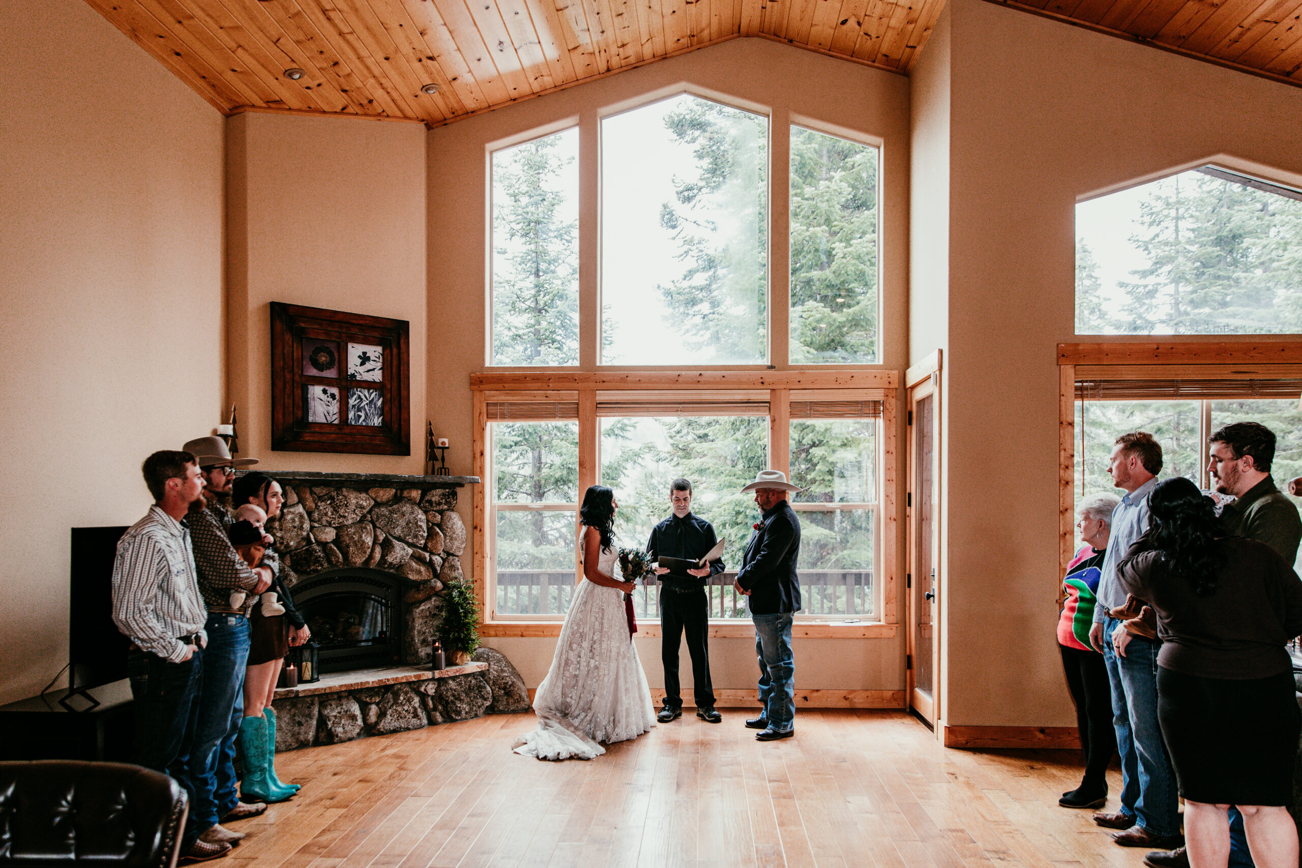 Couple exchanging vows inside a mountain cabin surrounded by windows and forest views, one of many elopement ideas in California