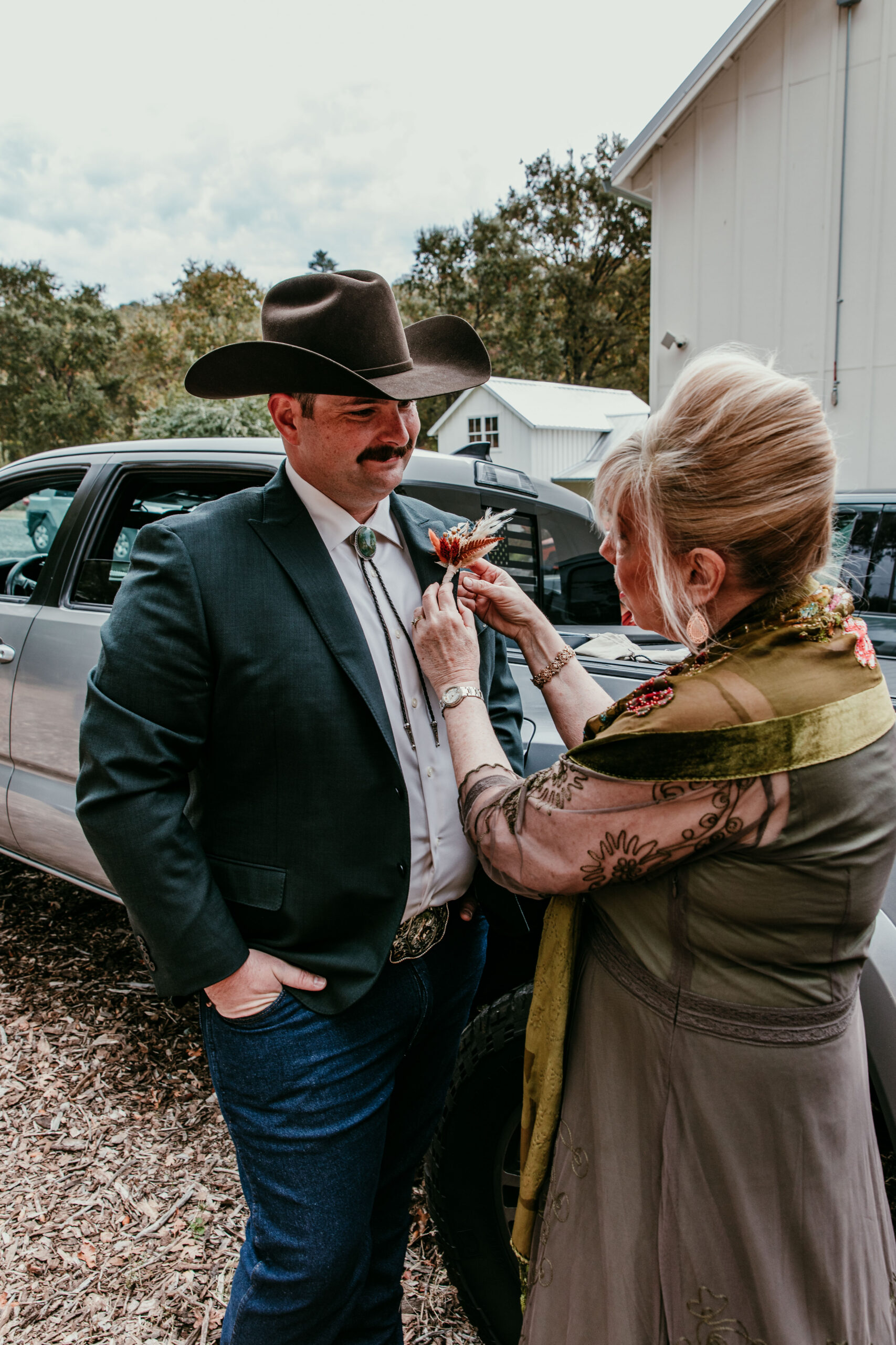 groom having boutonniere pinned while getting ready for a fall elopement in Yosemite