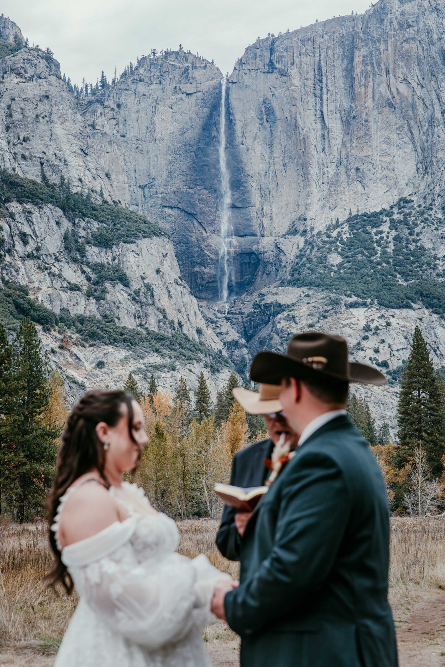 Couple saying vows with Yosemite Falls in the background showcasing epic elopement ideas in California