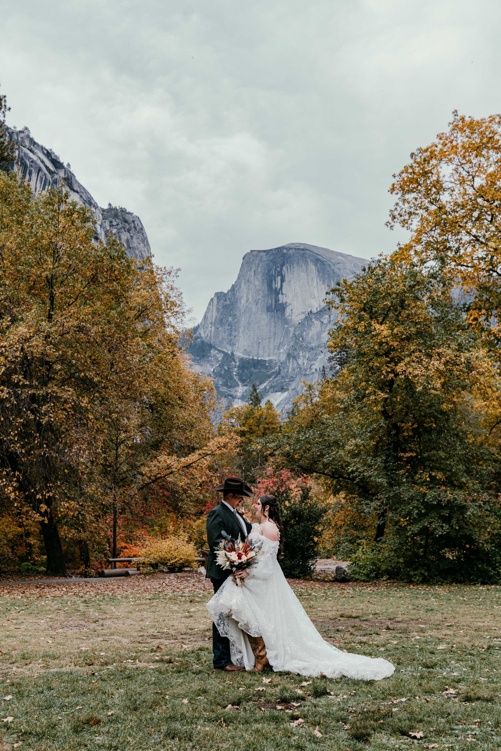 bride and groom with Half Dome in Yosemite Valley during their fall elopement in Yosemite National Park