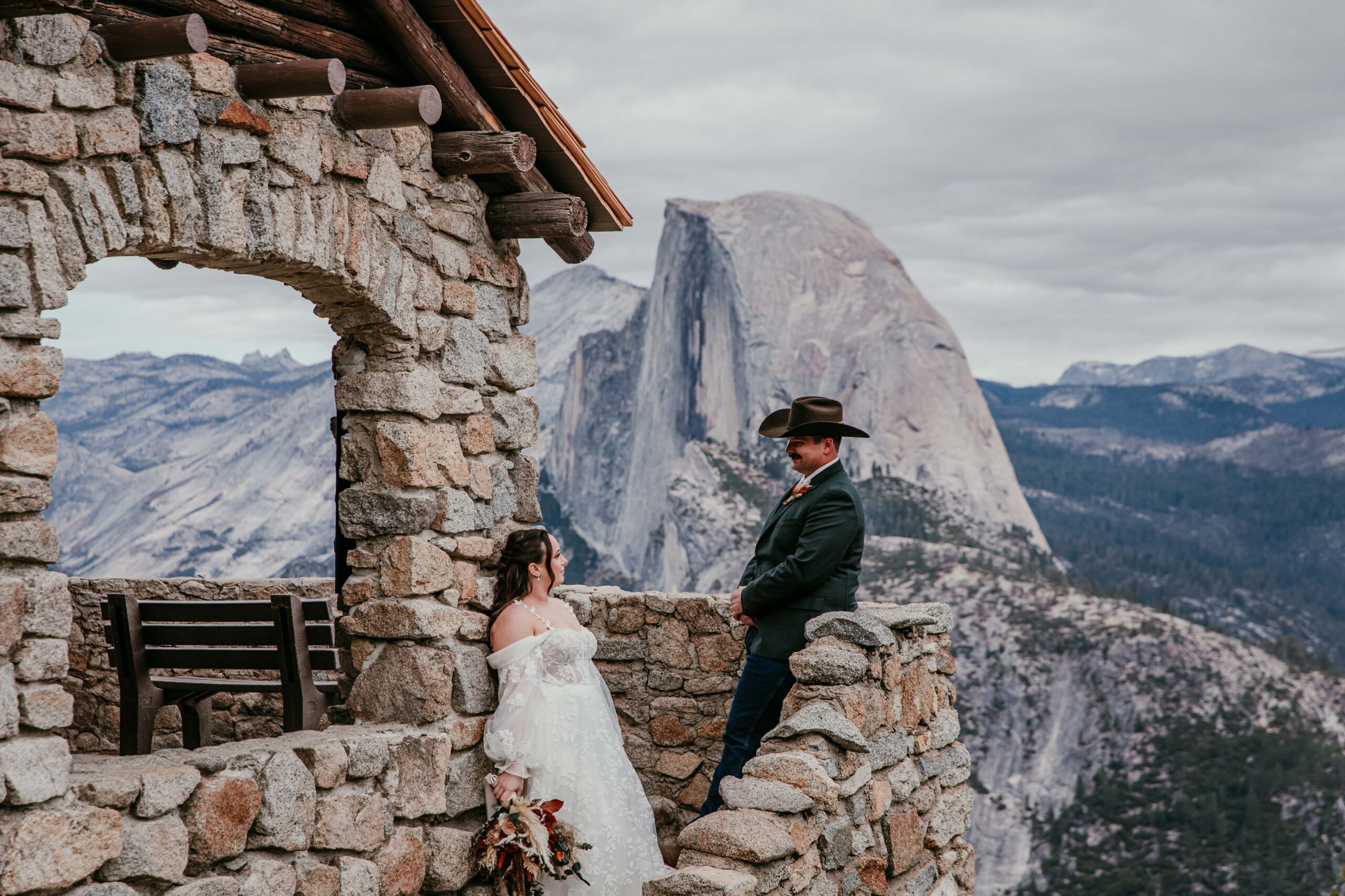 Couple at stone structure overlooking Half Dome Yosemite, intimate national park wedding ideas setting
