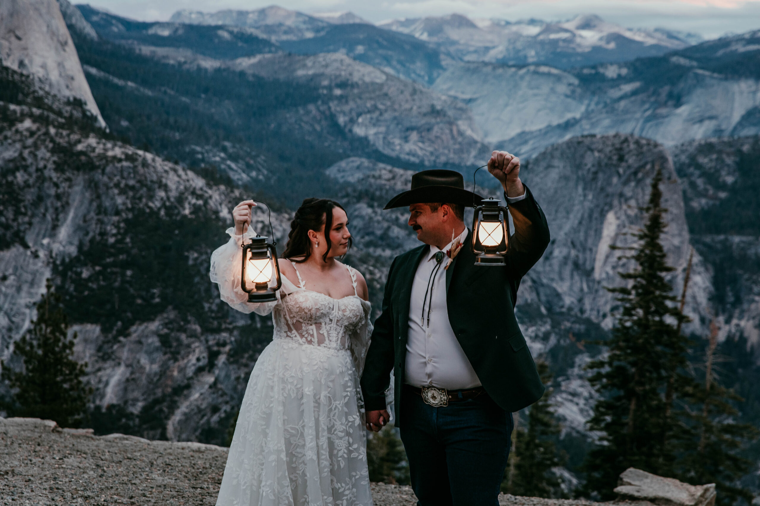 couple holding lanterns at Glacier Point during blue hour after their fall elopement in Yosemite