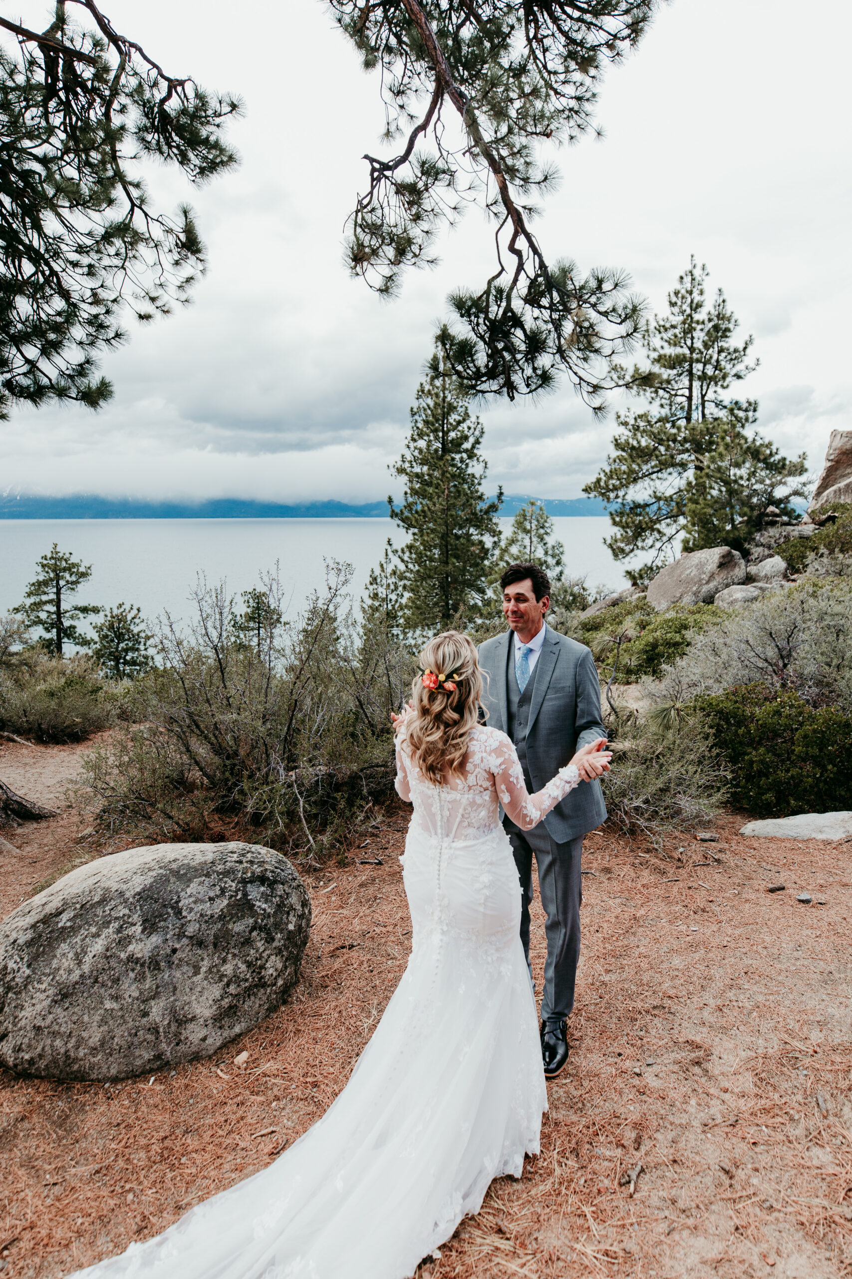 Bride and groom seeing each other for the first time during their rainy Lake Tahoe elopement first look at Logan Shoals Vista Point.