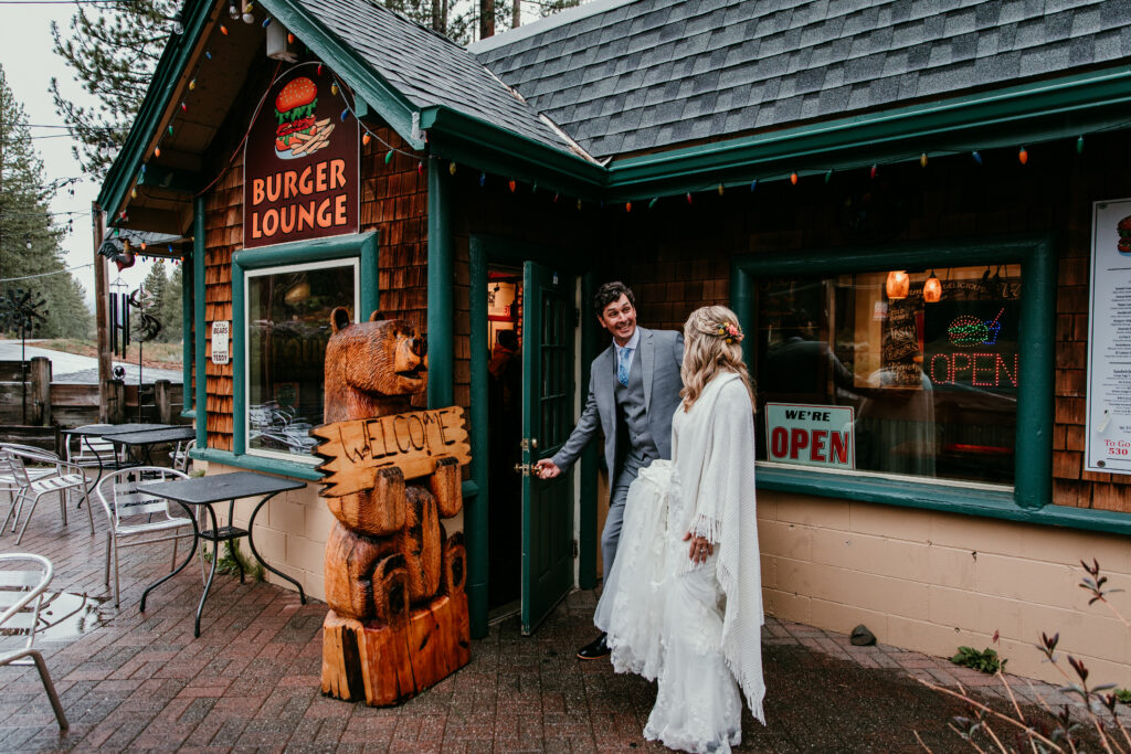 Bride and groom walking into Burger Lounge to warm up during their rainy Lake Tahoe elopement.