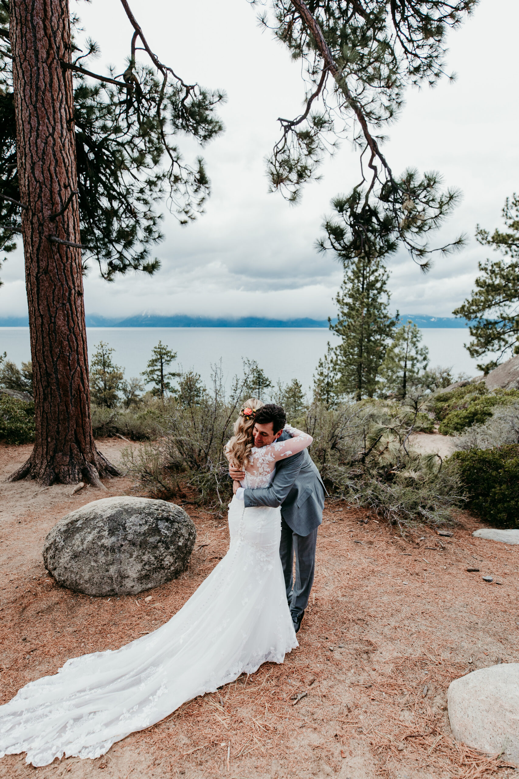Bride and groom hugging after their first look during a rainy Lake Tahoe elopement overlooking Lake Tahoe.