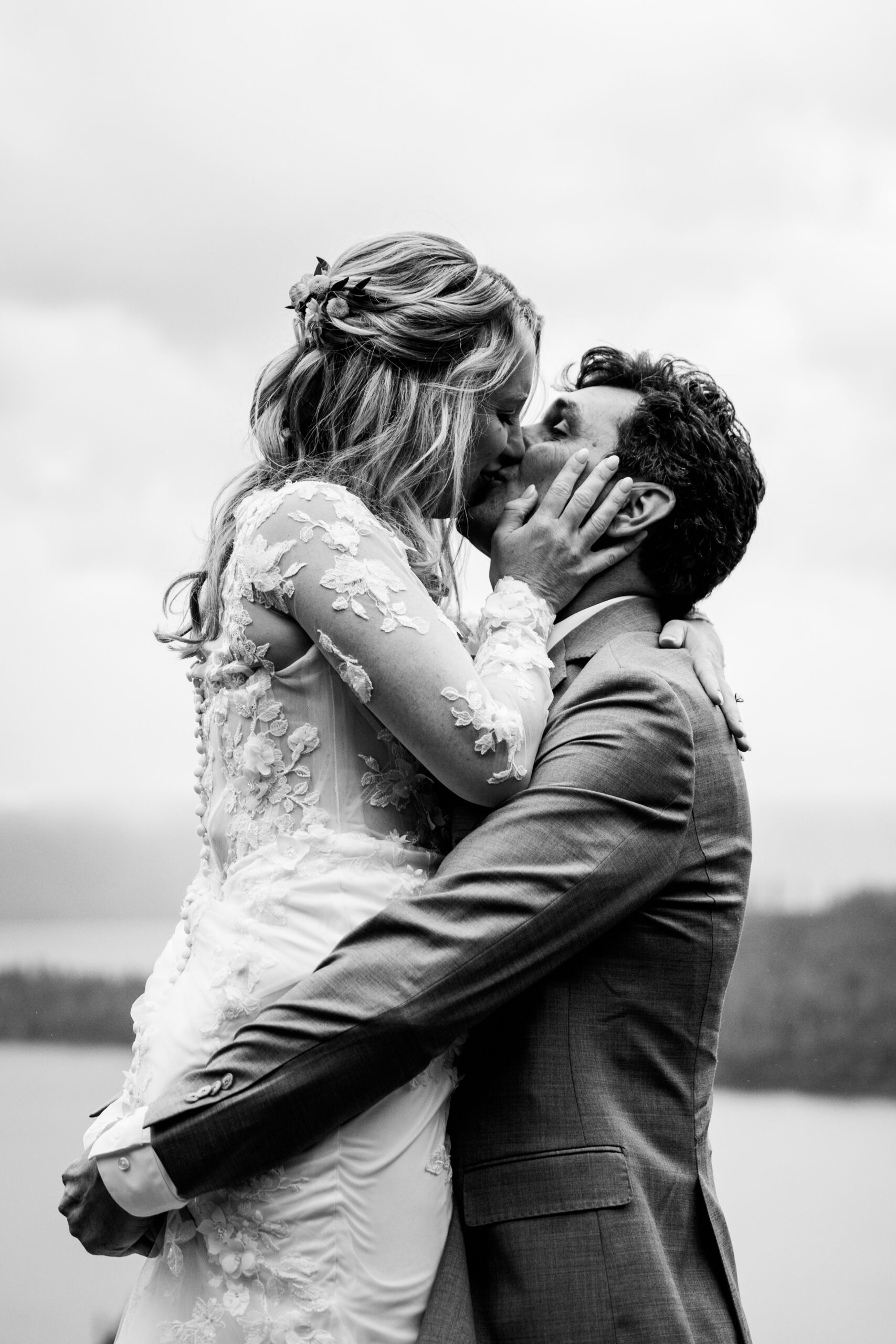 Black and white close-up of the bride and groom sharing a kiss during their rainy Lake Tahoe elopement at Emerald Bay.