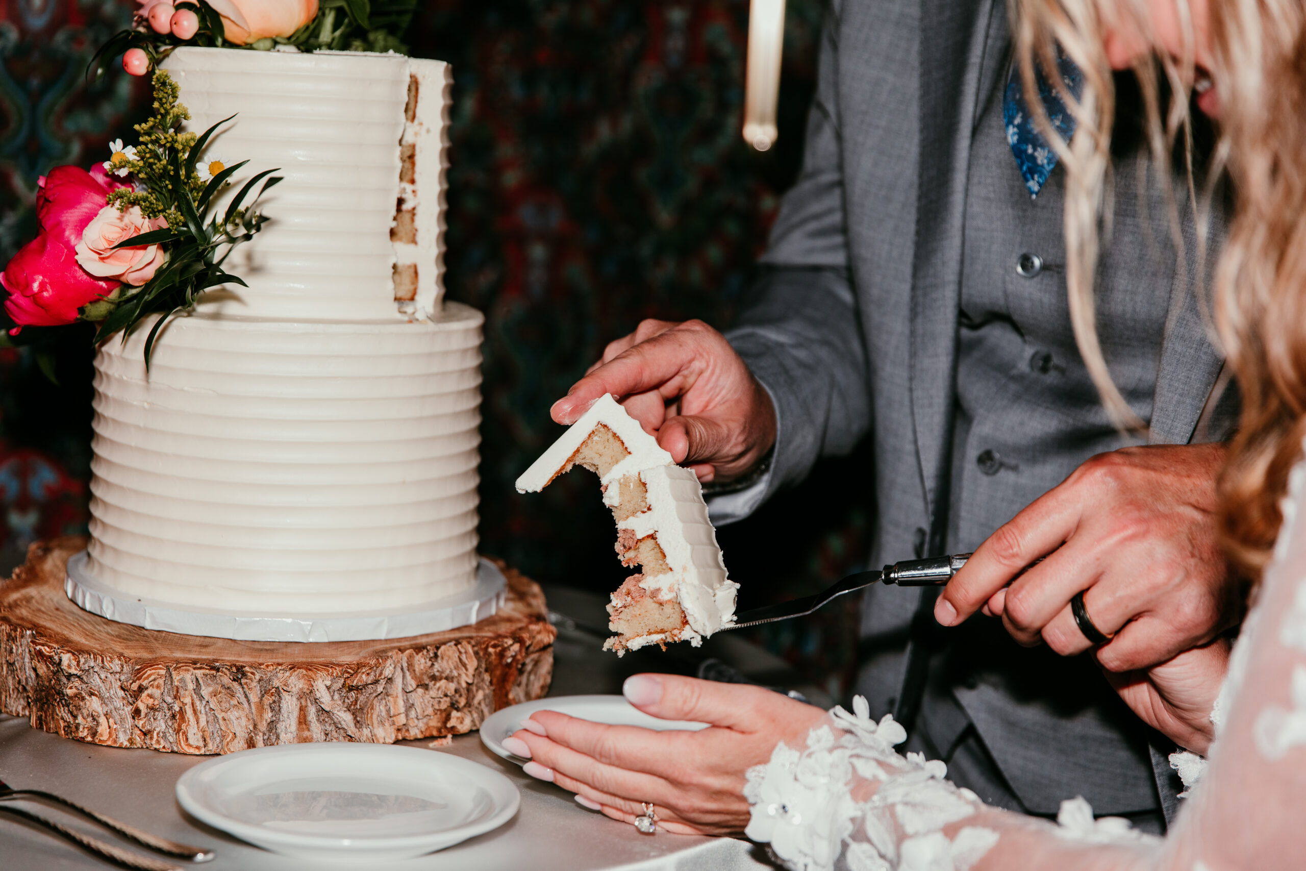 Close-up of the bride and groom serving their wedding cake during the reception after their rainy Lake Tahoe elopement at The Landing Resort.