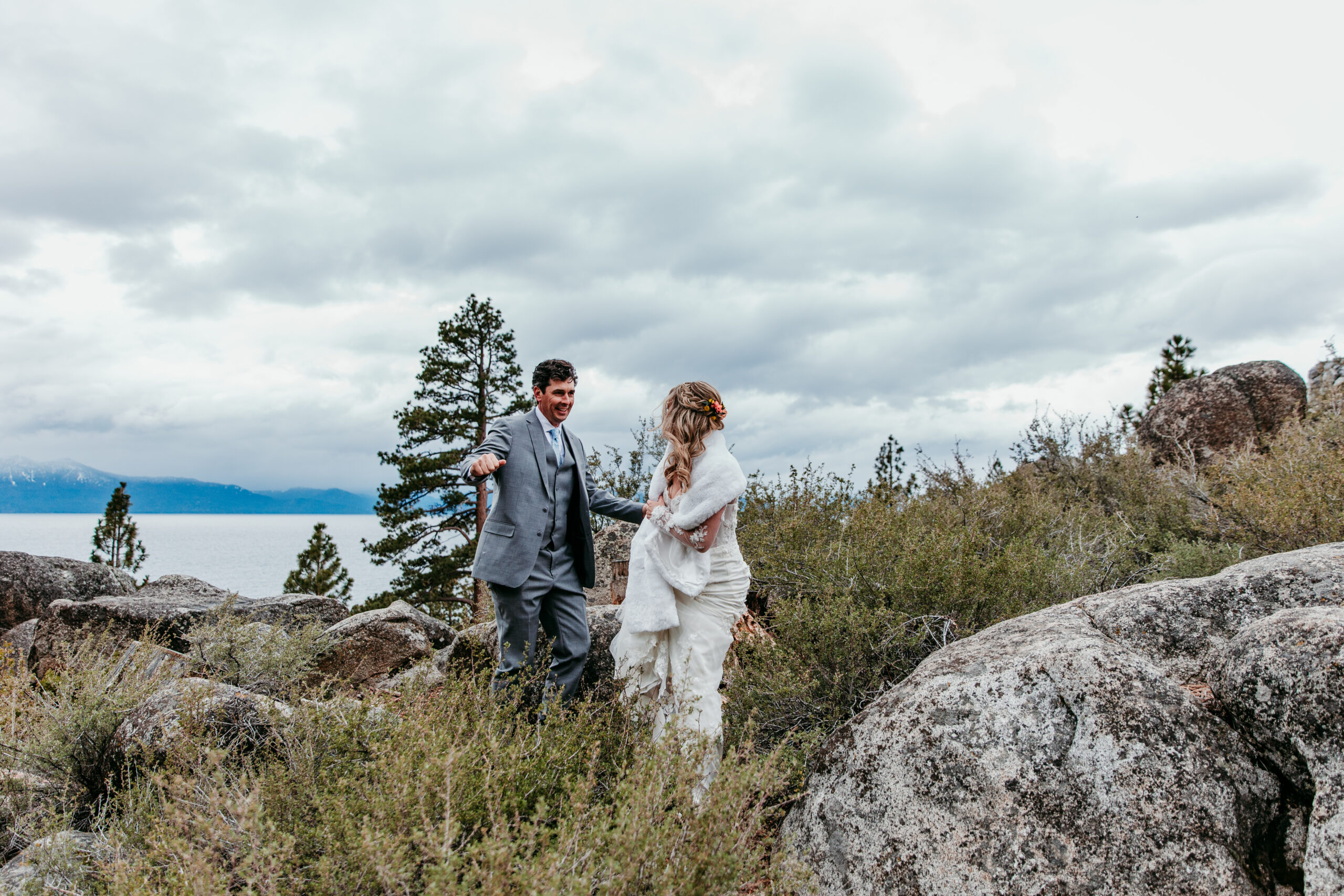 Bride and groom laughing together while exploring the trails after their rainy Lake Tahoe elopement at Emerald Bay.