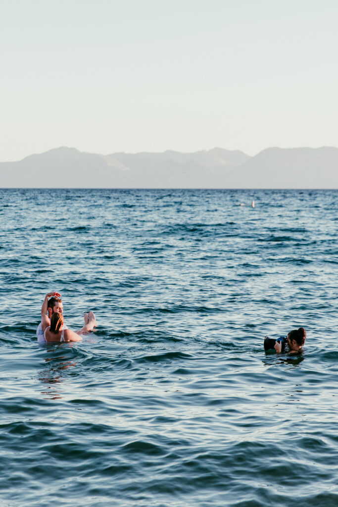 Photographer in Lake Tahoe capturing SJ and Dave playing in the water during their summer elopement.